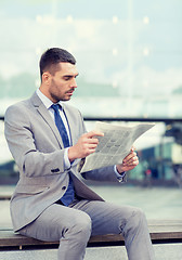 Image showing young serious businessman newspaper outdoors