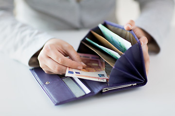 Image showing close up of woman hands with wallet and euro money