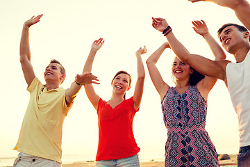 Image showing smiling friends dancing on summer beach