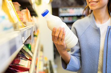 Image showing happy woman holding milk bottle in market