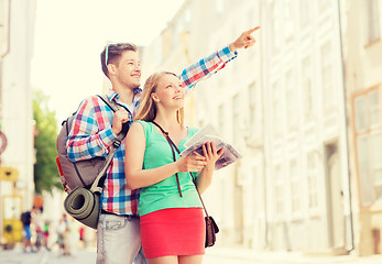 Image showing smiling couple with city guide and backpack