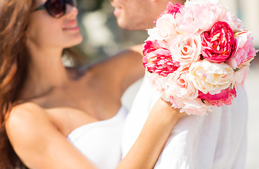 Image showing close up of couple with bunch flowers in city