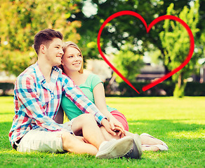 Image showing smiling couple sitting on grass in summer park