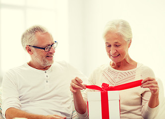 Image showing happy senior couple with gift box at home