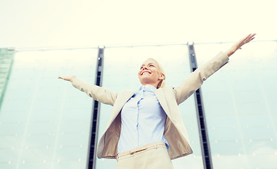 Image showing young smiling businesswoman over office building