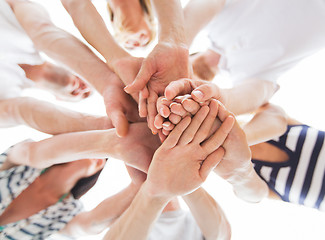 Image showing close up of friends with hands on top