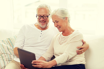 Image showing happy senior couple with tablet pc at home