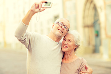 Image showing senior couple photographing on city street