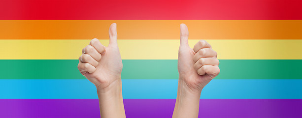 Image showing hands showing thumbs up over rainbow background