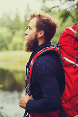 Image showing smiling man with beard and backpack hiking
