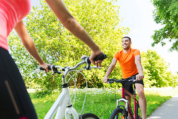 Image showing close up of happy couple riding bicycle outdoors