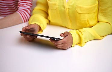 Image showing close up of female hands with tablet pc at table