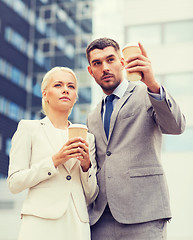 Image showing serious businessmen with paper cups outdoors