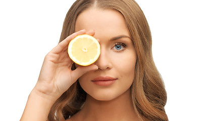 Image showing beautiful woman face with lemon slice over eye