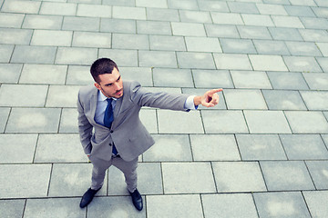 Image showing young smiling businessman outdoors from top