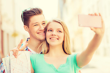 Image showing smiling couple with smartphone in city