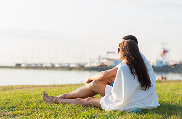 Image showing close up of couple sitting on grass at seaside