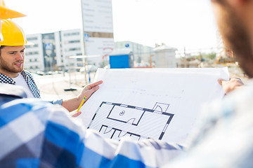 Image showing close up of builders with blueprint at building