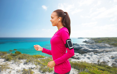 Image showing happy woman with smartphone running on beach