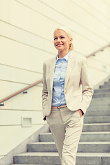Image showing young smiling businesswoman walking down stairs