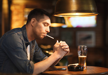 Image showing man drinking beer and smoking cigarette at bar