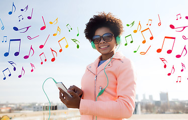 Image showing happy young woman with smartphone and headphones