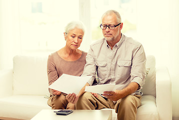 Image showing senior couple with papers and calculator at home