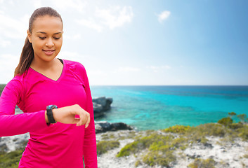 Image showing smiling woman with heart rate watch on beach