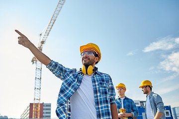 Image showing builders pointing finger aside on construction