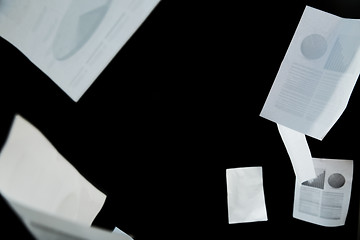 Image showing business papers falling down over black background