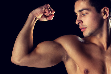 Image showing close up of young man showing biceps