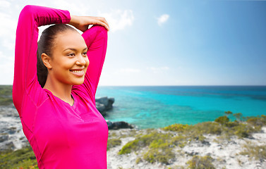 Image showing smiling african woman stretching hand on beach