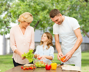 Image showing happy family cooking vegetable salad for dinner