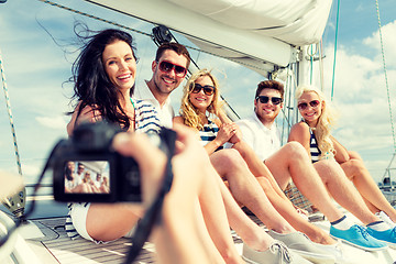 Image showing smiling friends photographing on yacht