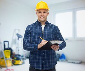 Image showing smiling male builder in helmet with clipboard