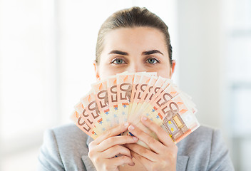 Image showing woman hiding her face behind euro money fan