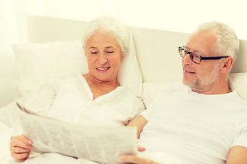 Image showing happy senior couple with newspaper in bed