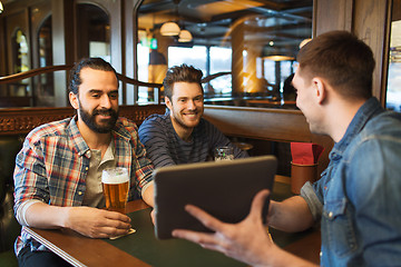 Image showing male friends with tablet pc drinking beer at bar