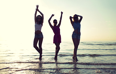 Image showing happy female friends dancing on beach