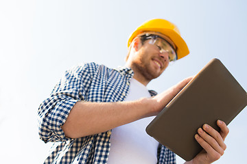 Image showing close up of builder in hardhat with tablet pc