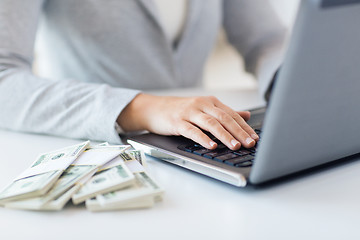 Image showing close up of woman hands with laptop and money