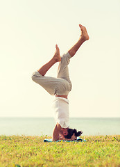 Image showing man making yoga exercises outdoors