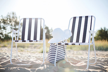 Image showing two beach lounges with beach bag and white hat