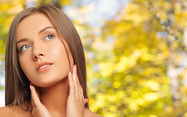 Image showing beautiful young woman touching her neck