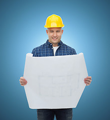 Image showing smiling male builder in helmet with blueprint