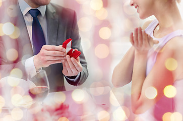 Image showing excited young woman and boyfriend giving her ring