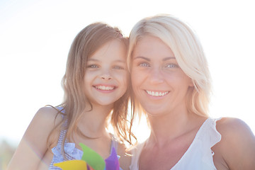 Image showing happy mother and child girl with pinwheel toy