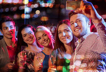 Image showing friends taking selfie by smartphone in night club