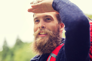 Image showing smiling man with beard and backpack hiking