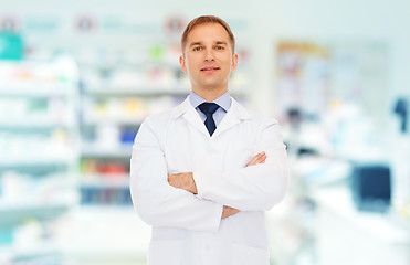 Image showing smiling male pharmacist in white coat at drugstore